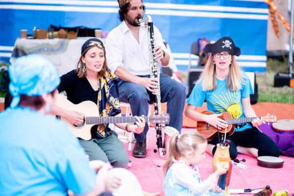 Furthest From The Sea event from Sinfonia VIva, people dressed as pirates playing instruments to children and adults sat on a red mat