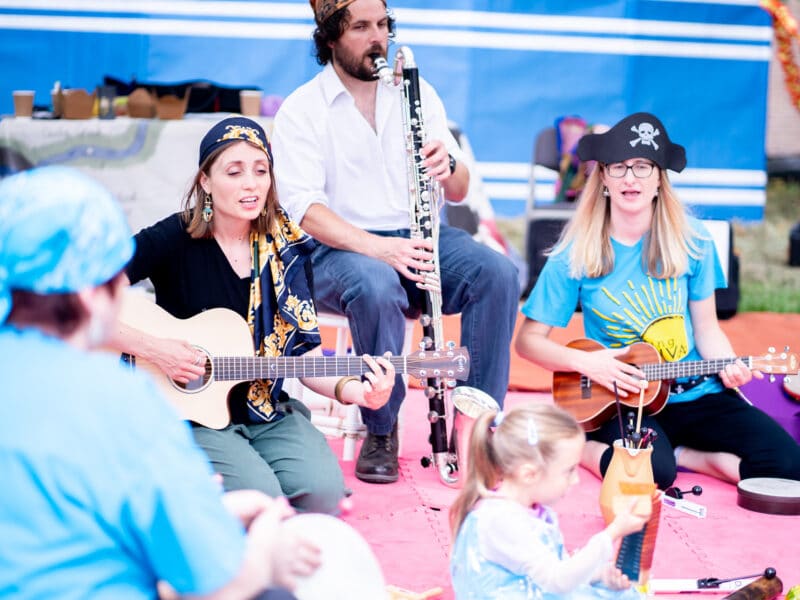 Furthest From The Sea event from Sinfonia VIva, people dressed as pirates playing instruments to children and adults sat on a red mat
