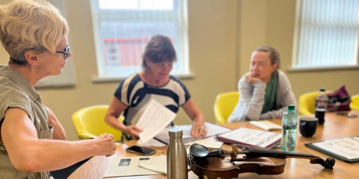 Three Sinfonia Viva musicians prepare for The Wandering Minstrels projects, choosing the sheet music they are going to play