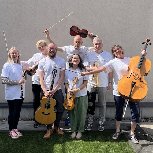 Seven Sinfonia Viva musicians pose for a group photo with their instruments